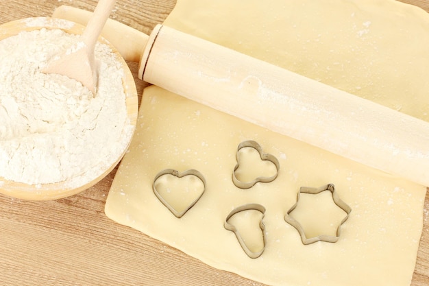 Tins of cookies on the rolled out dough close-up