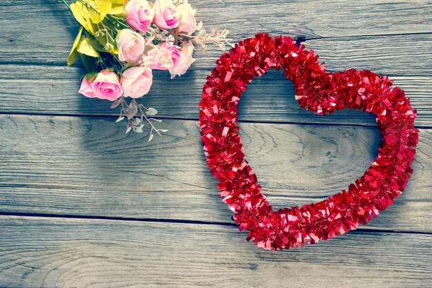 Tinsel heart decoration on wood backgroundfilter effect