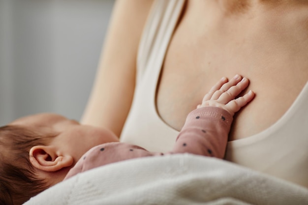 Фото Крошечная детская рука на груди мамы