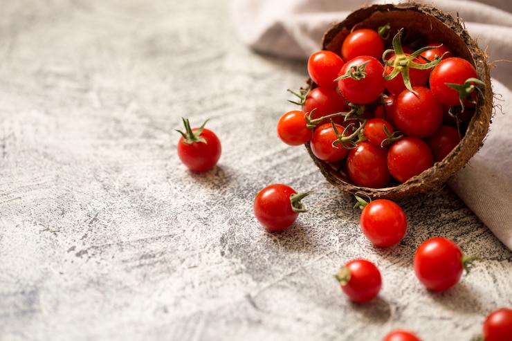 Photo tiny cherry tomatoes (ciliegini, pachino, cocktail). group of cherry tomatoes on a gray concrete  ripe and juicy cherry tomatoes