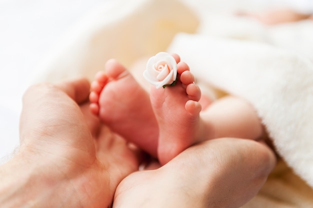 Piccoli piedi. primo piano della mano dei genitori che tiene i piedini del piccolo bambino