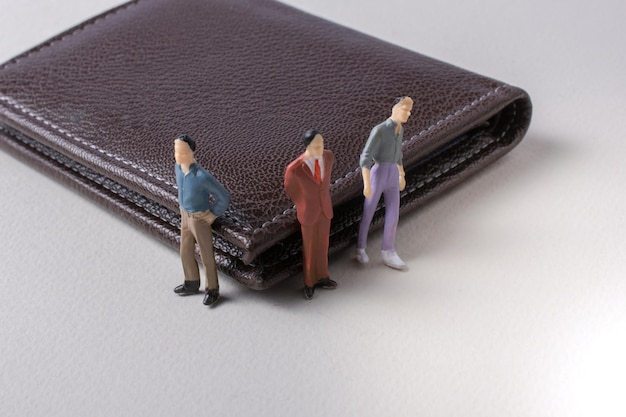 Tiny figurine of men miniature model beside a wallet