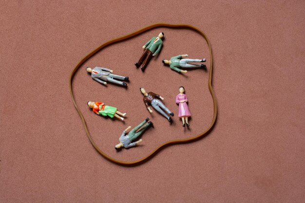 Tiny figurine of men and women circled with rubber band