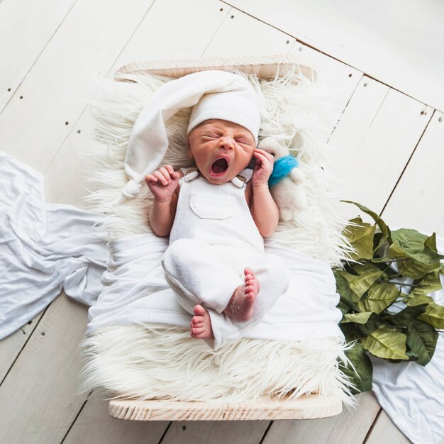 Foto piccolo neonato che dorme e sbadiglia