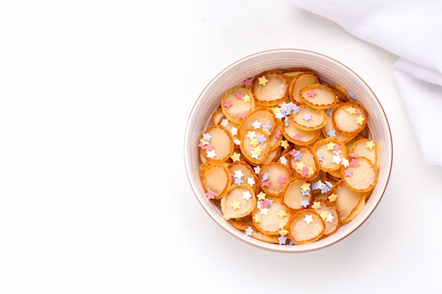 Tiny pancake cereal in a bowl.