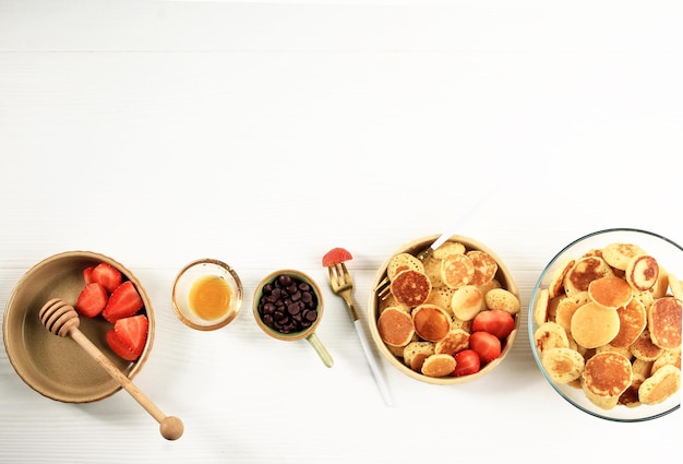 Tiny Pancake Cereal met aardbeien en muntblaadjes op een witte achtergrond. Trendy eten in 2020 met Copy Space.