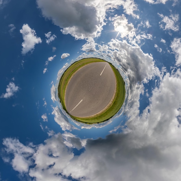 Tiny planet in blue overcast sky with beautiful clouds with transformation of spherical panorama 360 degrees Spherical abstract aerial view Curvature of space