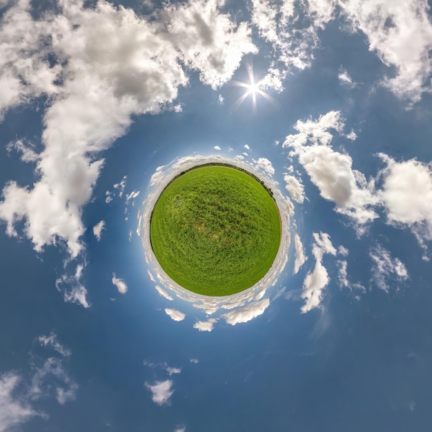 Tiny planet in blue sky with sun and beautiful clouds Transformation of spherical panorama 360 degrees Spherical abstract aerial view Curvature of space