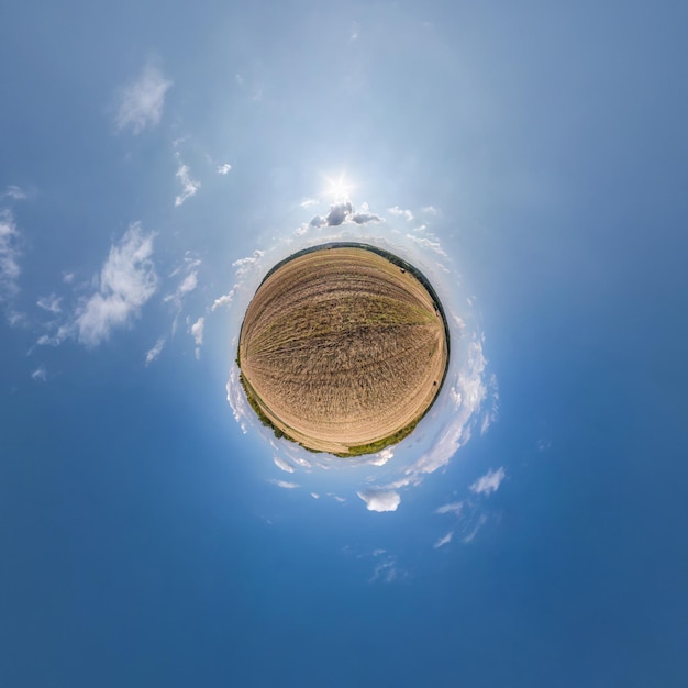 Tiny planet in blue sky with sun and beautiful clouds Transformation of spherical panorama 360 degrees Spherical abstract aerial view Curvature of space