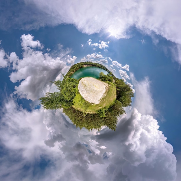 Tiny planet in blue sky with sun and beautiful clouds Transformation of spherical panorama 360 degrees Spherical abstract aerial view Curvature of space