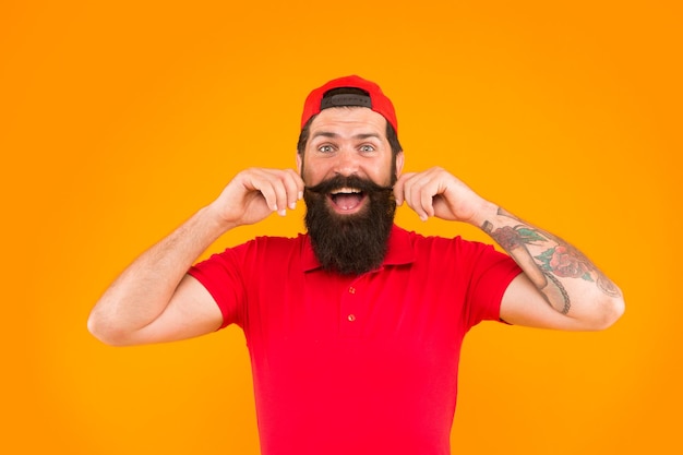 Tips for growing and maintaining moustache Cool and stylish Man bearded hipster twisting mustache orange background Barber salon Moustache grooming guide Hipster handsome guy touching moustache