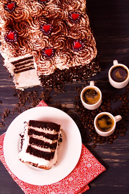 Tiramisu cake, multiple layers of espresso infused chocolate cake, filled with chocolate mascarpone mousse and topped with whipped cream.