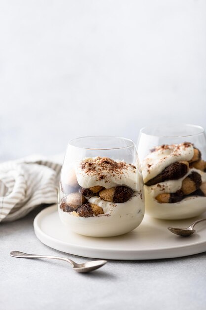 Tiramisu-dessert in een glas op een lichte achtergrond