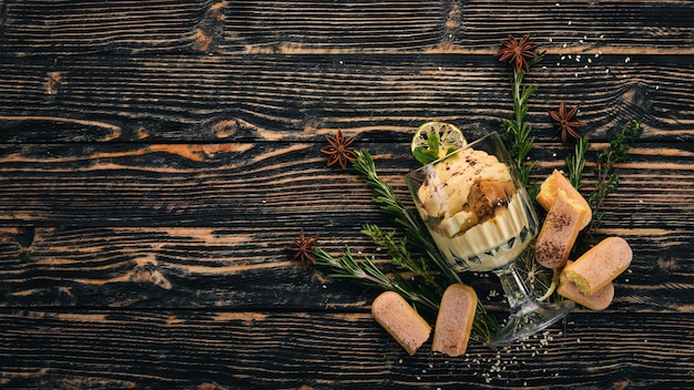 Foto dessert tiramisù. vista dall'alto. su uno sfondo di legno nero. copia spazio.