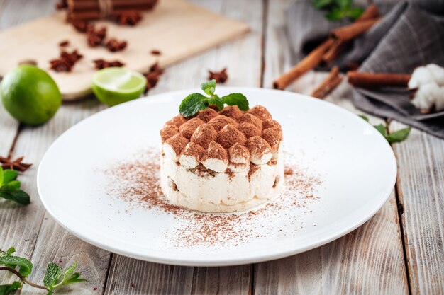 Dessert tiramisù con menta su un piatto bianco