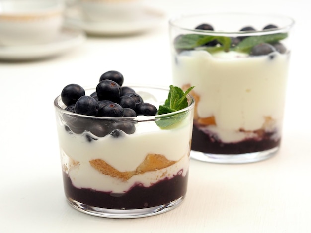 Tiramisu or dessert of yogurt with blueberries and savoiardi in a glass