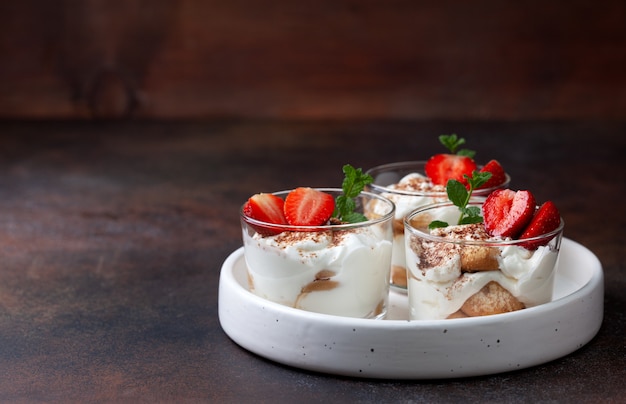 Tiramisu in een glas met verse aardbeien