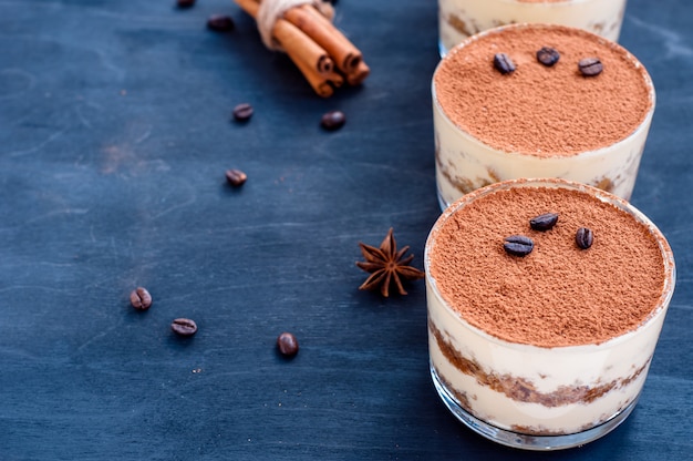 Tiramisu in een glas versierd met koffiebonen op een donkere achtergrond