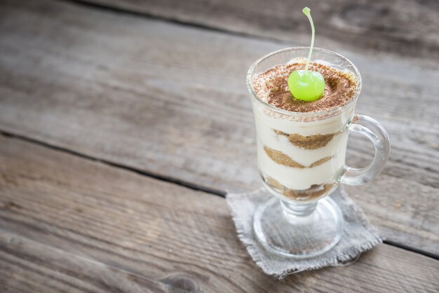 Tiramisu in het glas op de houten tafel