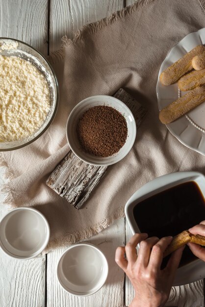 Tiramisu koken op de witte houten tafel verticaal