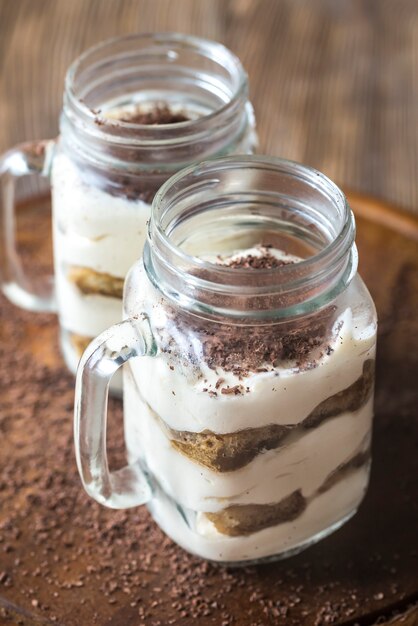 Tiramisu in the mason jars on the wooden table