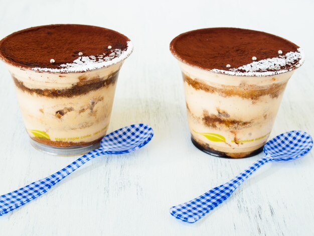 Tiramisu mousse with custom decoration served in plastic cup.