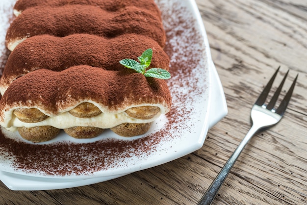 Tiramisu on the plate on the wooden table