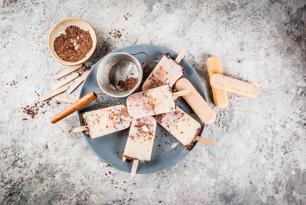 Gelato ai ghiaccioli al tiramisù. il gelato si apre con biscotti savoiardi italiani, mascarpone, cioccolato al latte