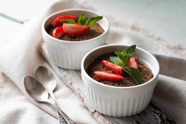 Tiramisu in the ramekins on the white table horizontal