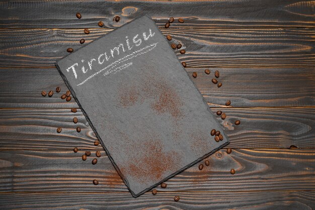 Photo tiramisu sign written on a chalkboard on rustic background