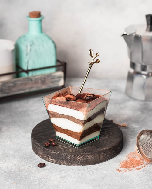 Tiramisu. Traditionele Italiaanse dessert op het glas op grijze stenen muur versierd met chocolade koffiebonen bestrooid met cocao poeder