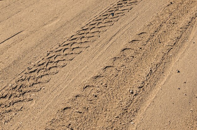 모래에서 타이어 흔적, 모래 배경에서 타이어 트랙
