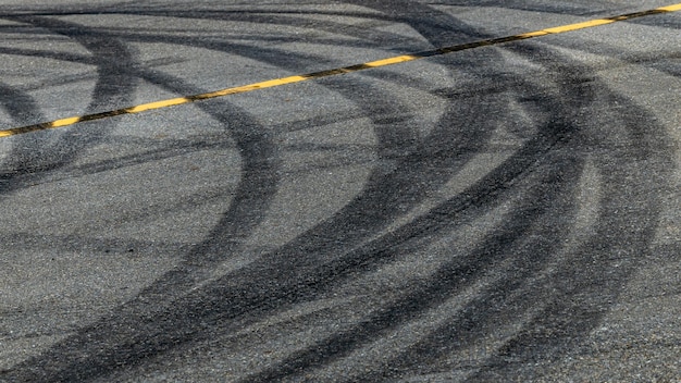 Tire track mark on asphalt tarmac road race track texture and background Abstract background black tire tracks skid on asphalt road in racing circuit Tire mark skid mark on asphalt road