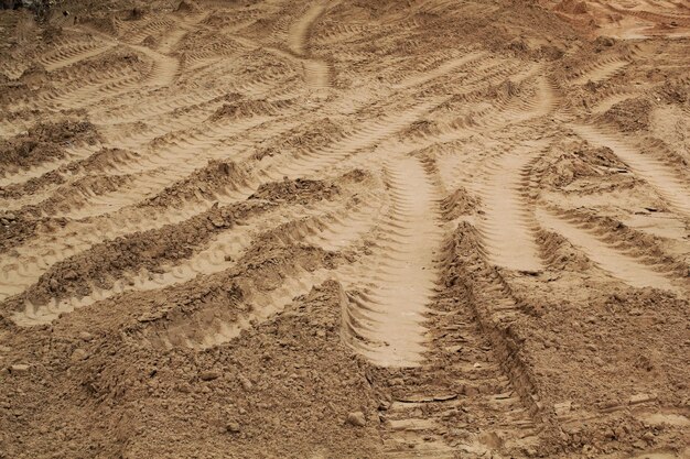 Tire track mark lines shape on dry sand background. Trail tyre imprint from heavy machinery. Vehicle