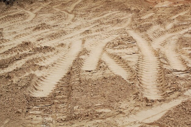 Tire track mark lines shape on dry sand background. Trail tyre imprint from heavy machinery. Vehicle