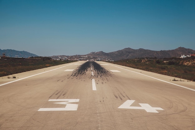 Foto tracce di pneumatici sulla pista dell'aeroporto contro un cielo blu limpido