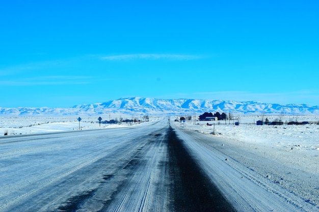 青い空を背景に雪の風景のタイヤの痕跡