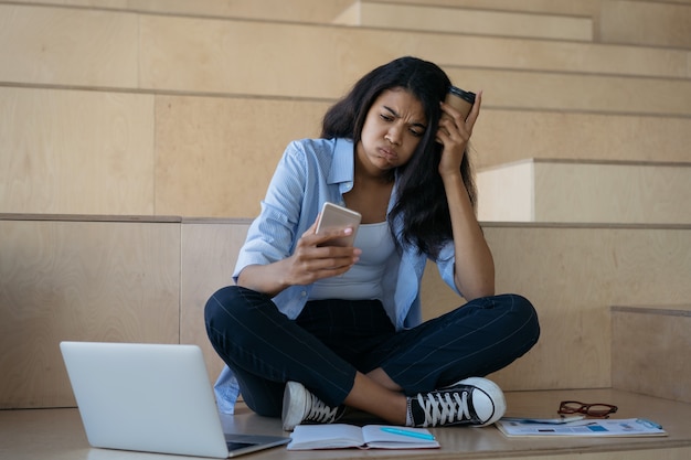 Studente afroamericano stanco che studia, che apprende, che prepara agli esami. ha sottolineato la donna che lavora sodo, scadenza mancata