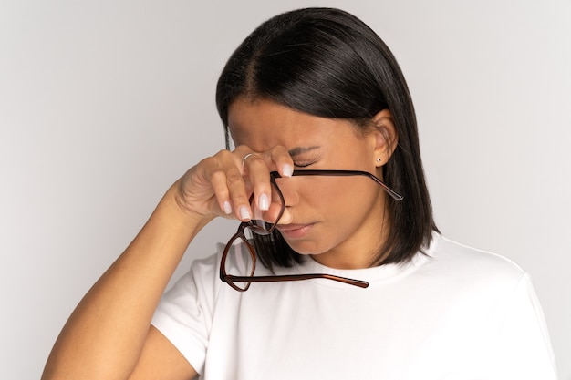 Tired african woman taking off glasses rubbing nose bridge\
suffer from strain and dry eyes syndrome