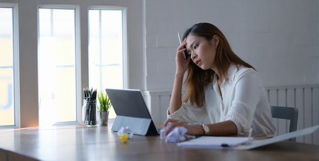 tired beautiful asian business woman working with headache in office room