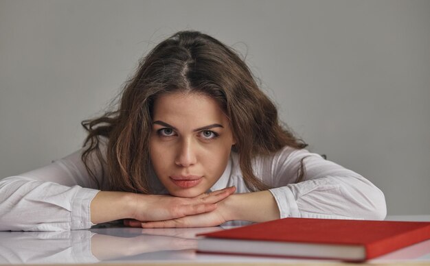 Tired bored teen girl upset by difficult learning looking at
books stack stressed by exam test preparation, overwhelmed student
exhausted with too much study homework cram, boring education
concept