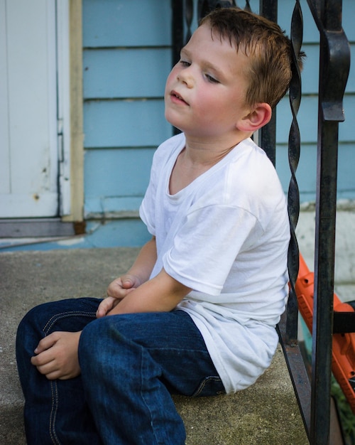 写真 階段に座っている疲れた少年