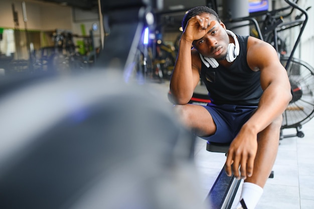 Tired breathing and fitness gym man taking a break from workout