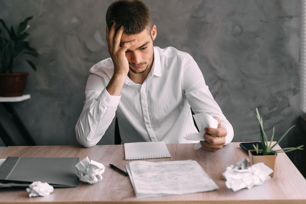 Tired burnt out businessman ponders a contract of difficulty with concentration Fatigue of an office worker Crisis at work notes exhaustion from a busy schedule Entrepreneurship concept