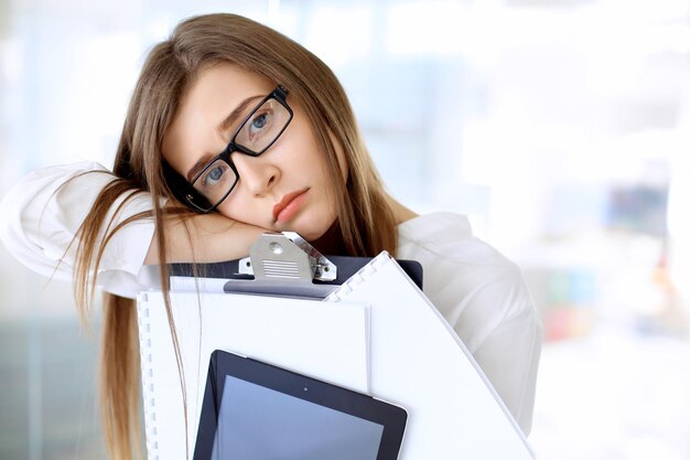 Tired business woman standing in the office