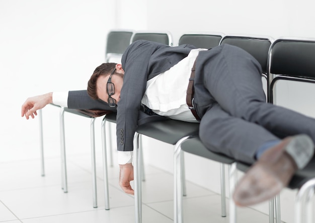 Tired businessman lying on chairs and waiting for an\
interview