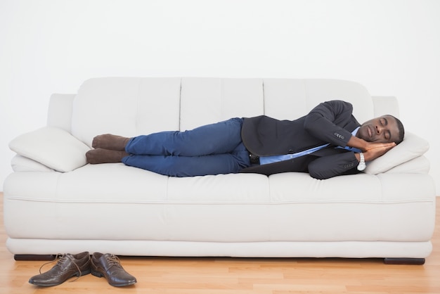 Tired businessman sleeping on sofa 