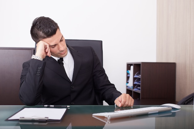 Tired businessman working in office