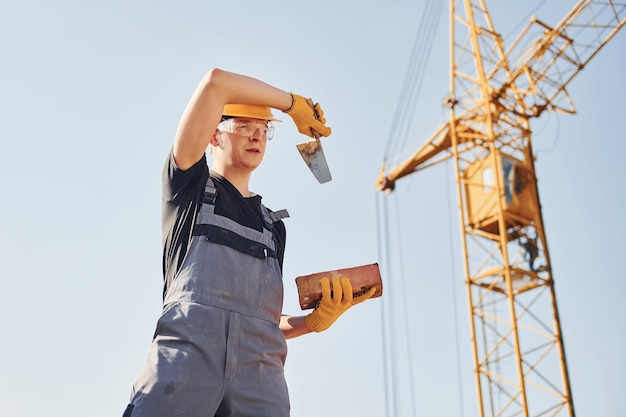 Tired construction worker in uniform and safety equipment have job on building