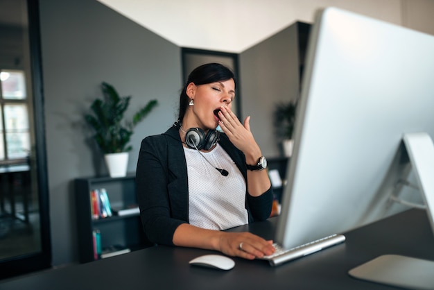 Tired customer service agent yawning.